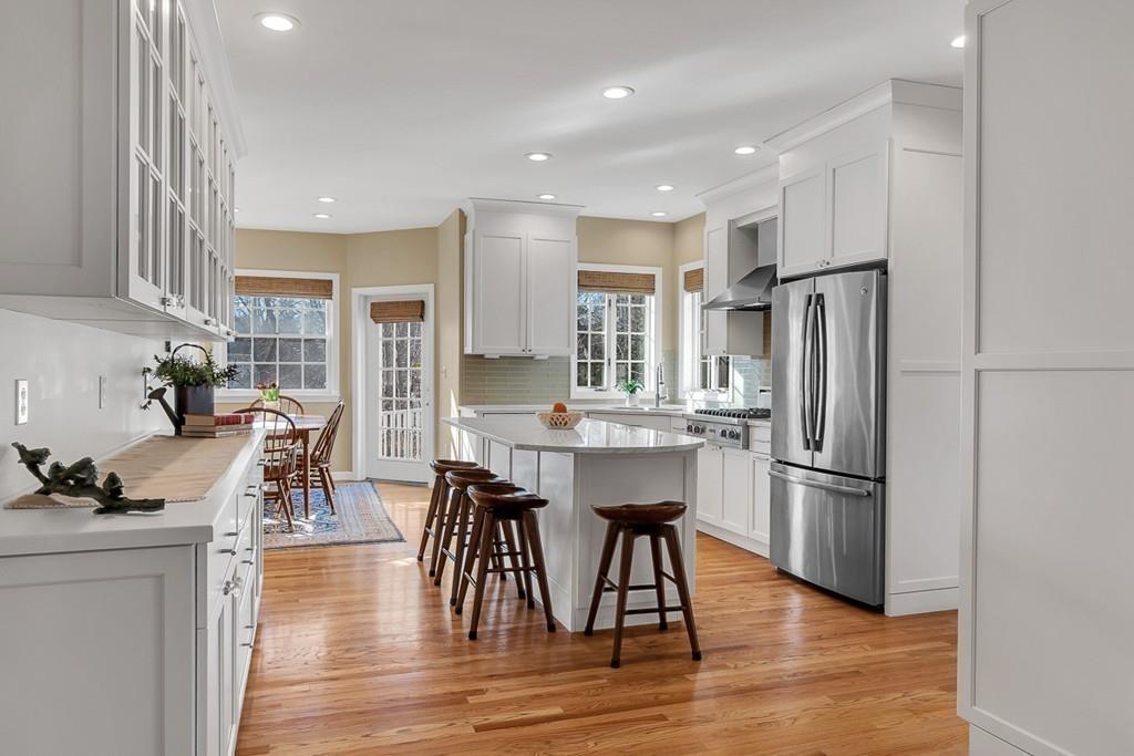 2 Sunset Rock Road Andover, MA 01810 - Photo 4 of 42 a kitchen with stainless steel appliances kitchen island granite countertop a refrigerator a stove a sink a dining table and chairs with wooden floor
