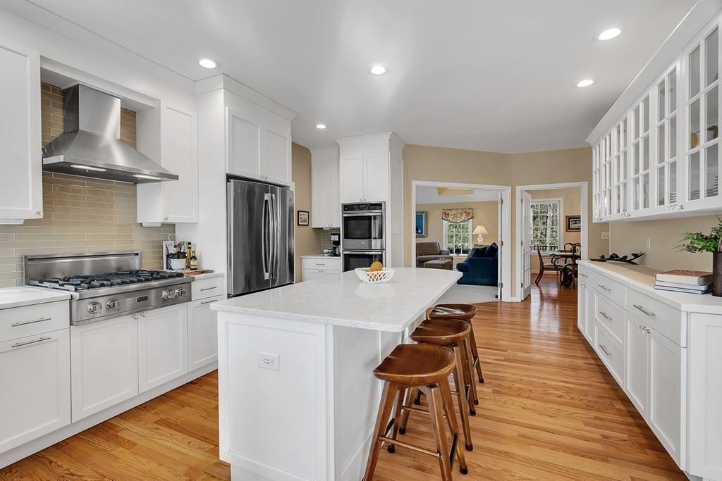 2 Sunset Rock Road Andover, MA 01810 - Photo 8 of 42 a large kitchen with stainless steel appliances kitchen island granite countertop a stove a refrigerator a sink a dining table and chairs with wooden floor