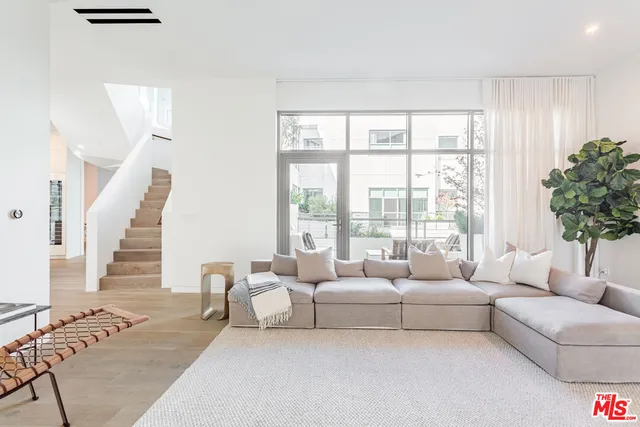 a living room with furniture and floor to ceiling windows