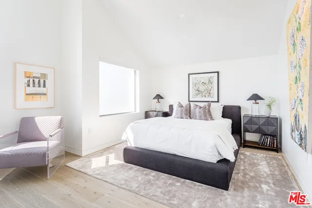 a spacious bedroom with a bed a couch and a window