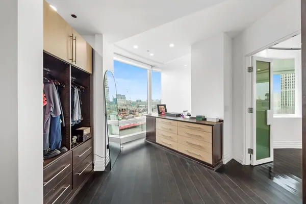 a view of a hallway with wooden floor and windows