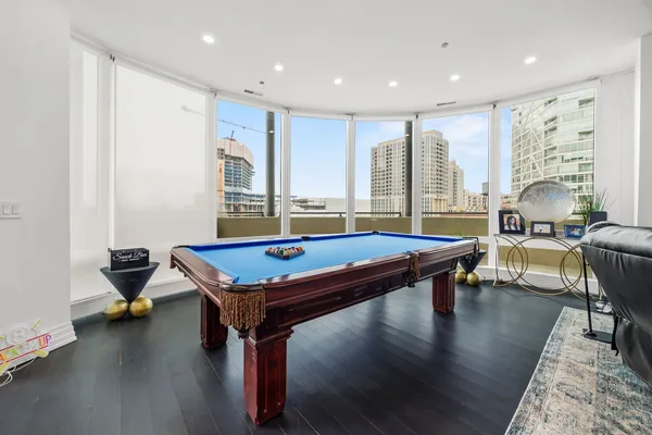 a room with furniture pool table flat screen tv and windows