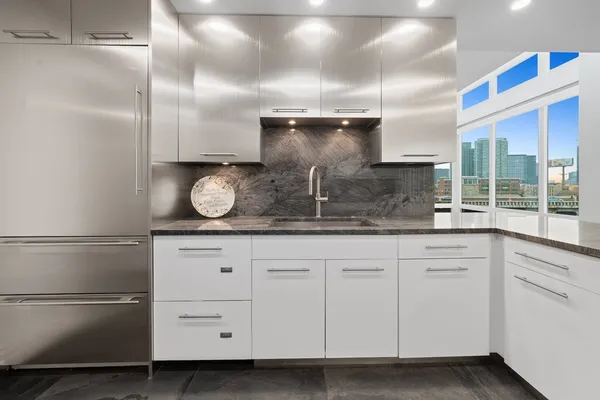 a kitchen with white cabinets and stainless steel appliances