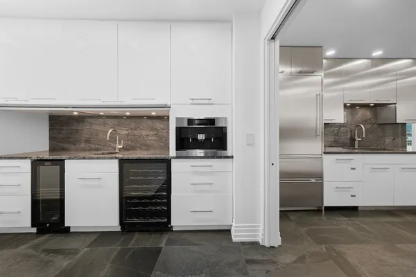 a kitchen with stainless steel appliances kitchen island granite countertop a stove and white cabinets