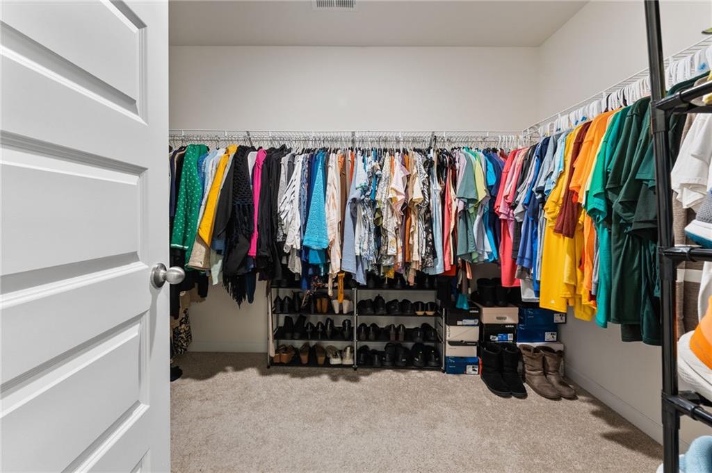 104 Waratah Drive Locust Grove, GA 30248 - Photo 17 of 27 a view of walk in closet with clothes and shoes