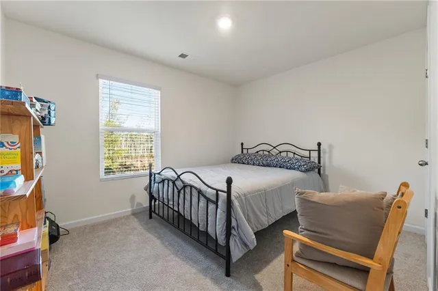 a bed sitting in a bedroom next to a window