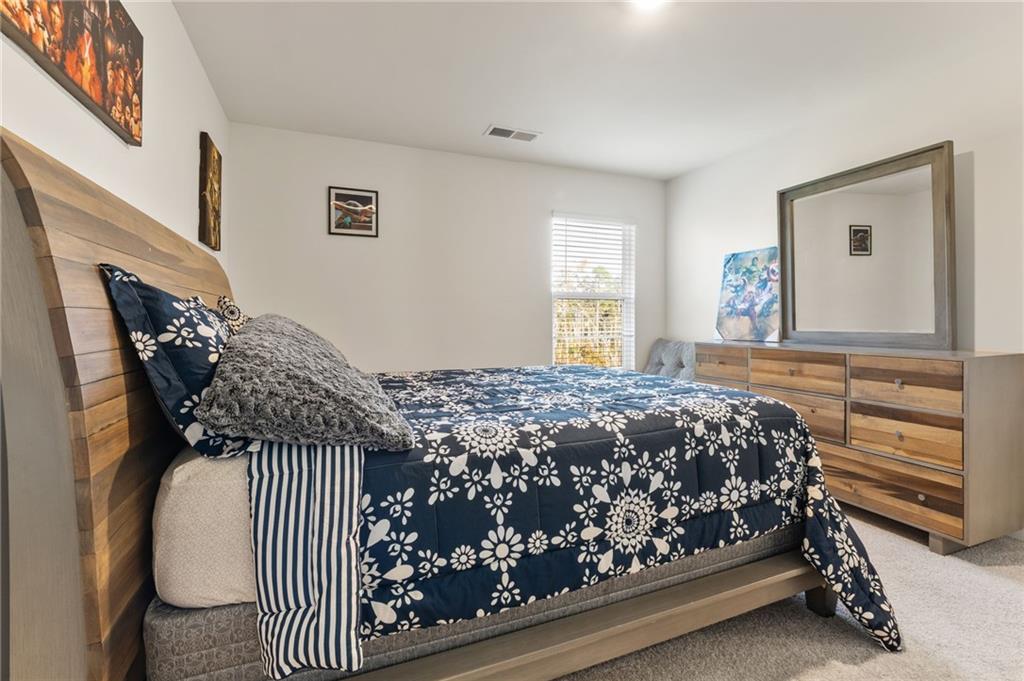 104 Waratah Drive Locust Grove, GA 30248 - Photo 21 of 27 a bed sitting in a bedroom next to a window
