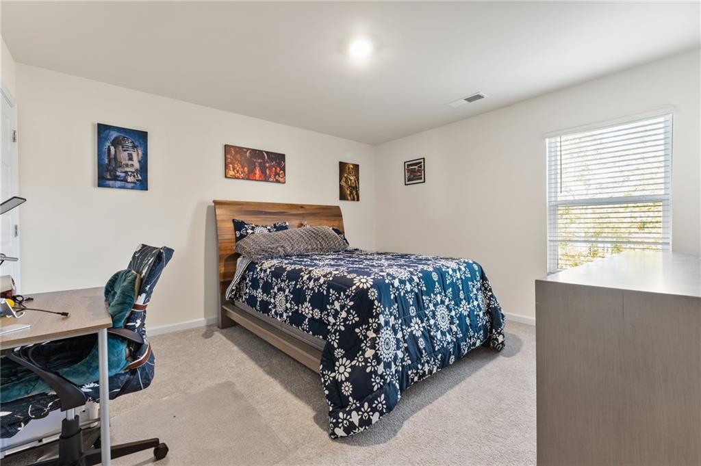 104 Waratah Drive Locust Grove, GA 30248 - Photo 22 of 27 a bedroom with a bed and a desk in it