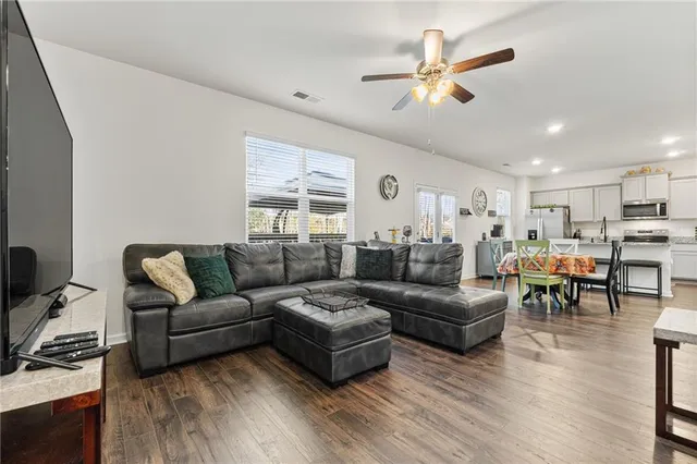 a living room with furniture kitchen view and a window