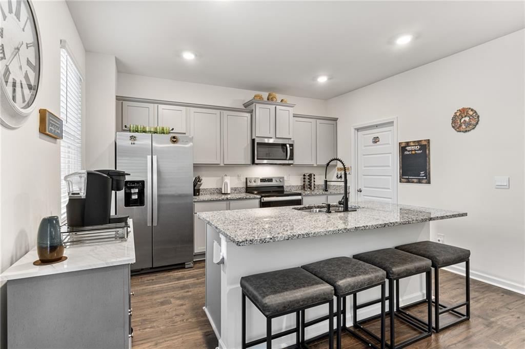104 Waratah Drive Locust Grove, GA 30248 - Photo 7 of 27 a kitchen with stainless steel appliances granite countertop a refrigerator a sink a stove a microwave and chairs