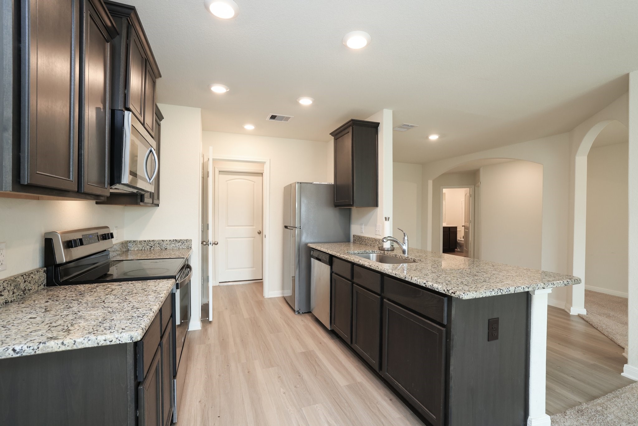 20914 Solstice Point Drive Hockley, TX 77447 - Photo 13 of 27 a kitchen with stainless steel appliances granite countertop a sink a stove and a refrigerator
