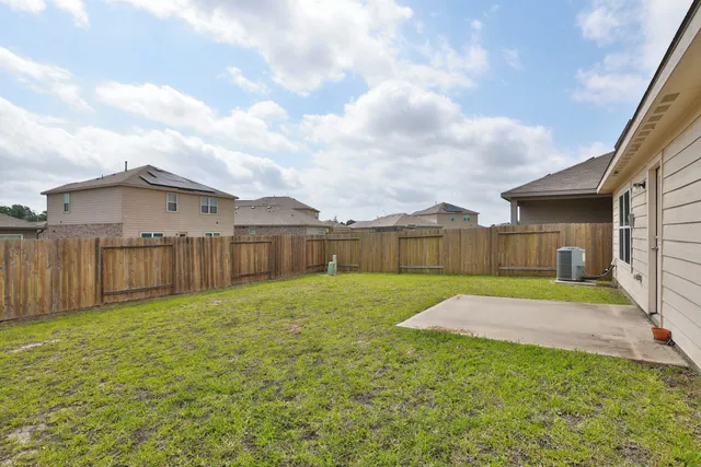 a view of backyard of house with wooden fence