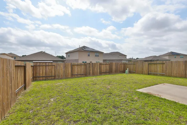 a house view with garden space and wooden fence