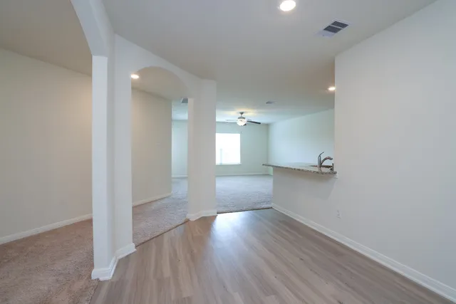 a view of empty room with wooden floor