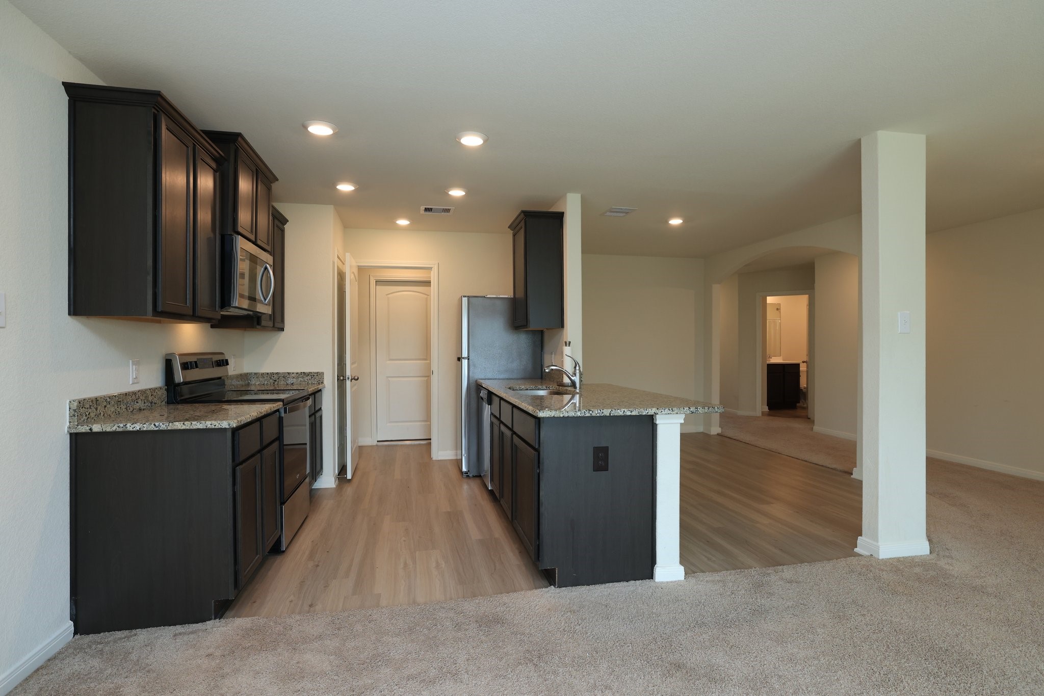 20914 Solstice Point Drive Hockley, TX 77447 - Photo 9 of 27 a kitchen with stainless steel appliances granite countertop a stove a sink and a refrigerator