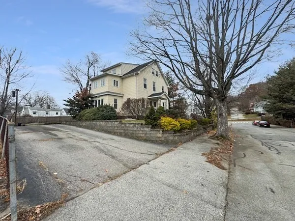 a front view of a house with a yard covered with snow