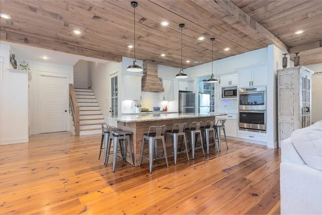 a open kitchen with kitchen island a large window a island and stainless steel appliances
