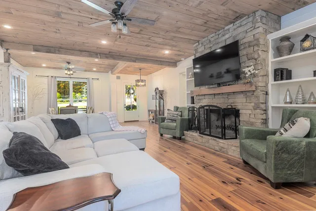a living room with furniture a flat screen tv and a fireplace