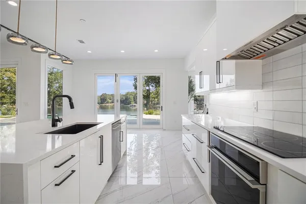 a kitchen with kitchen island granite countertop a sink window and cabinets