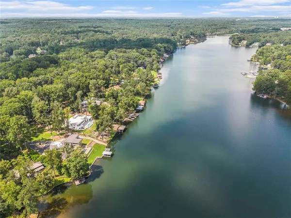 an aerial view of a house with a yard and lake view