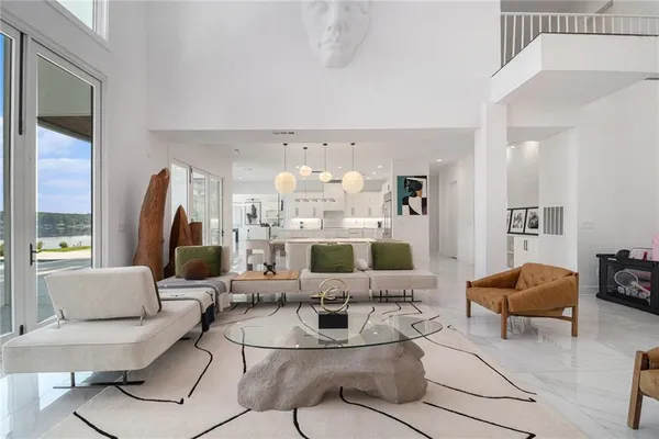 a large bedroom with furniture a flat screen tv and a large window