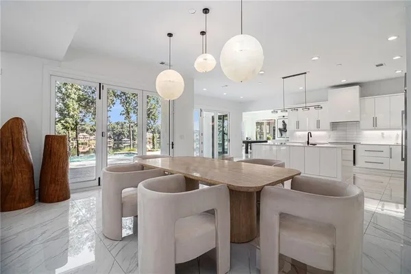 a kitchen with cabinets table and chairs