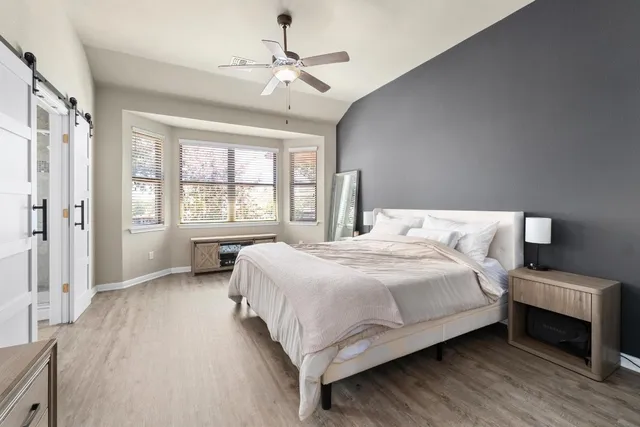 a bedroom with a large bed chandelier and a window
