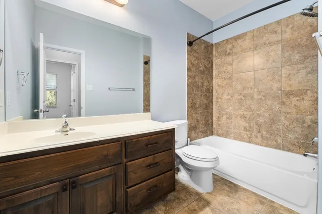 a bathroom with a double vanity sink toilet mirror and shower