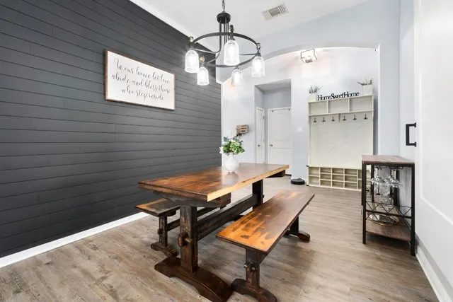a room with wooden floor table and chairs