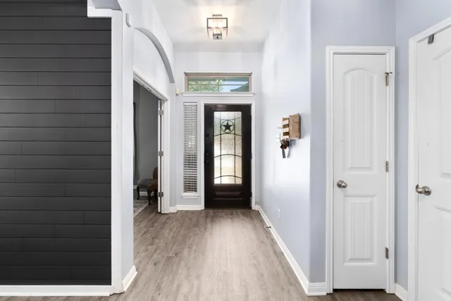 a view of a hallway with wooden floor and staircase