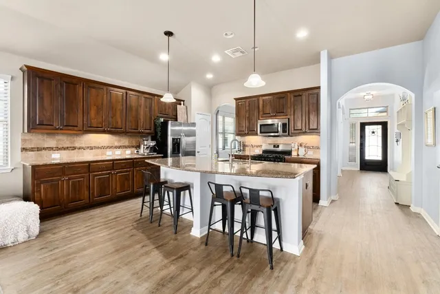 a kitchen with a sink a kitchen island and stainless steel appliances