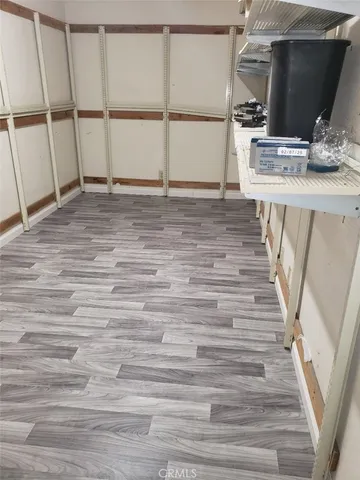a view of a kitchen with wooden floor and electronic appliances