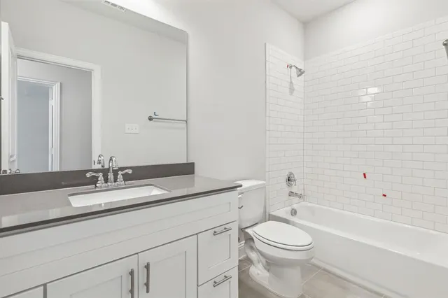 a bathroom with a granite countertop sink a toilet and a bathtub