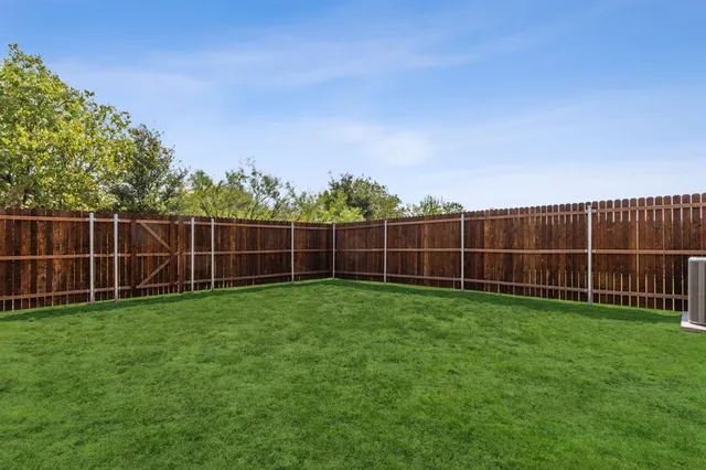 a view of a yard with a wooden fence