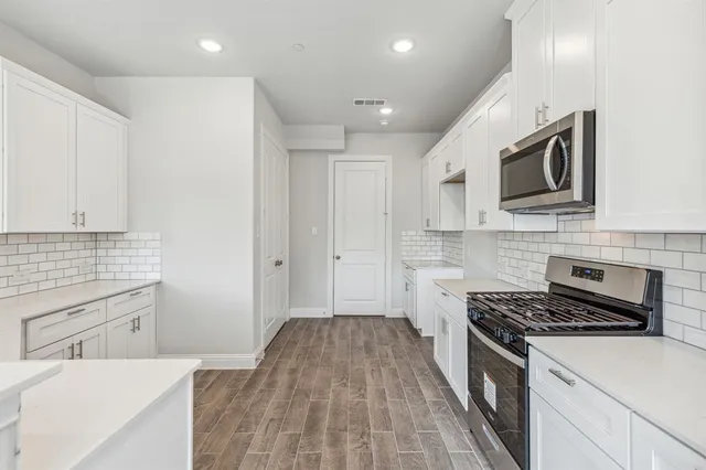 a kitchen with granite countertop cabinets stainless steel appliances and a counter space