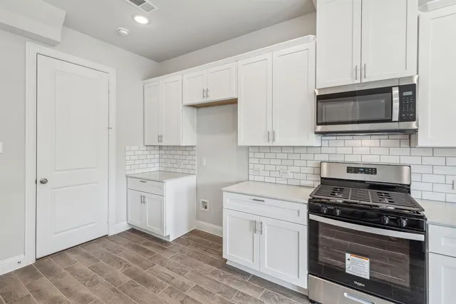 a kitchen with white cabinets stainless steel appliances and sink