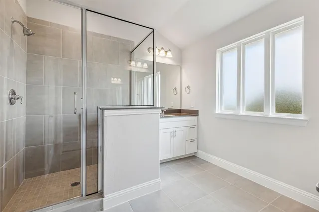 a bathroom with a granite countertop sink mirror and shower