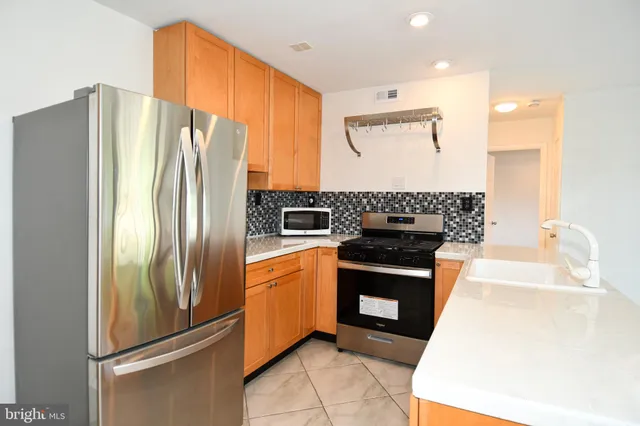 a kitchen with stainless steel appliances granite countertop a refrigerator and a stove