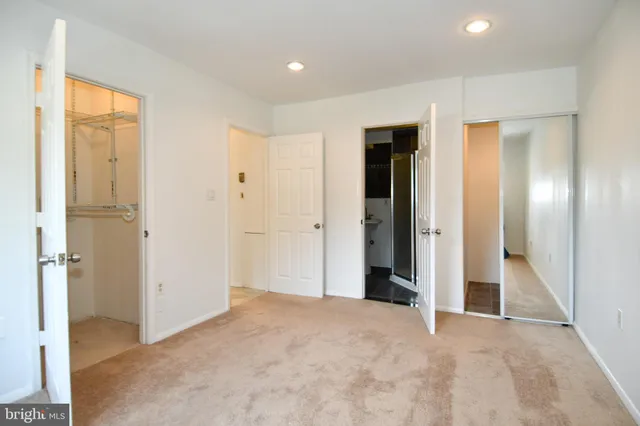 an empty room with closet and a bathroom