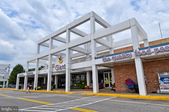 a view of a white house with a swimming pool and wooden fence
