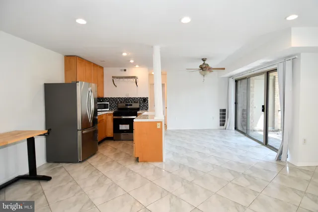 a view of a kitchen with refrigerator and a stove