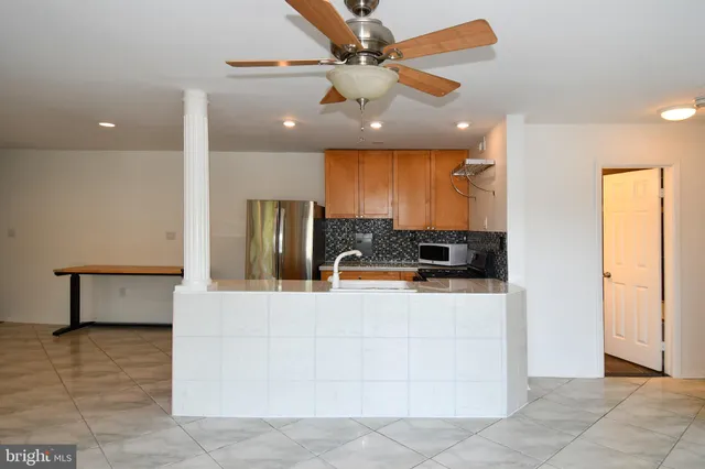 a kitchen with stainless steel appliances granite countertop a refrigerator a stove and a sink