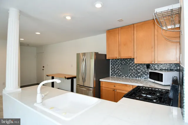 a kitchen with stainless steel appliances a stove a sink a microwave and cabinets