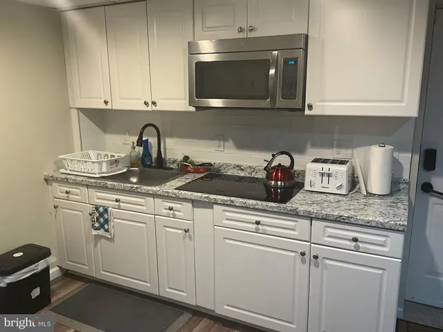 a kitchen with stainless steel appliances granite countertop white cabinets a sink and dishwasher