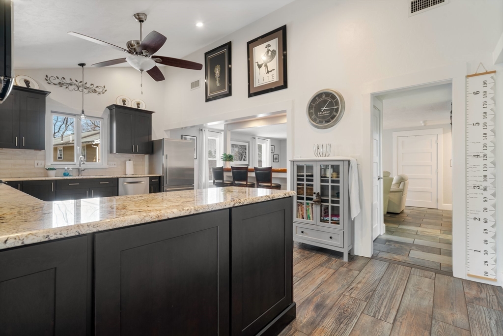9 Riverside Road Billerica, MA 01821 - Photo 6 of 42 a kitchen with stainless steel appliances granite countertop a refrigerator a oven a sink and a dining table with wooden floor