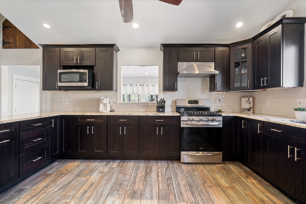 9 Riverside Road Billerica, MA 01821 - Photo 7 of 42 a kitchen with stainless steel appliances granite countertop wooden cabinets a stove top oven a sink and dishwasher