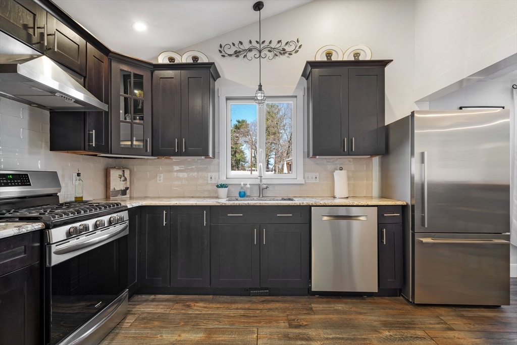 9 Riverside Road Billerica, MA 01821 - Photo 8 of 42 a kitchen with stainless steel appliances wooden cabinets and a stove top oven