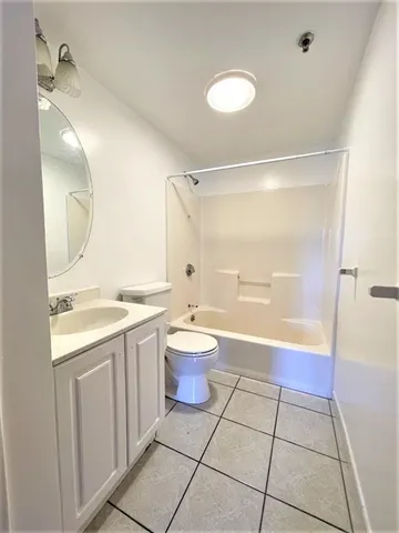 a bathroom with a granite countertop sink toilet a mirror and shower