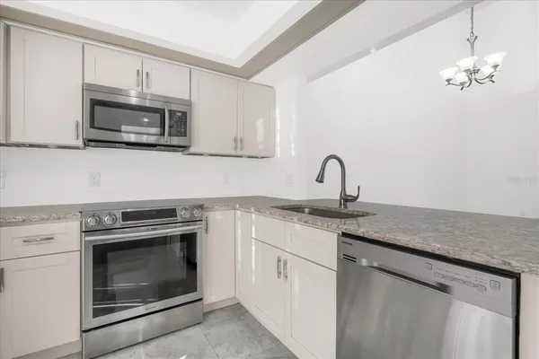 a kitchen with granite countertop a stove top oven and sink