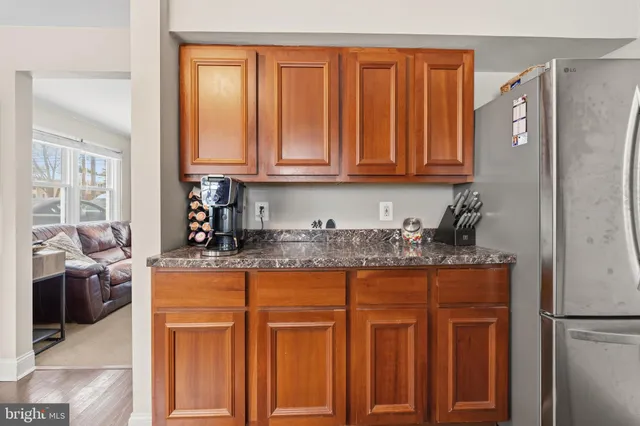 a kitchen with granite countertop a refrigerator and cabinets